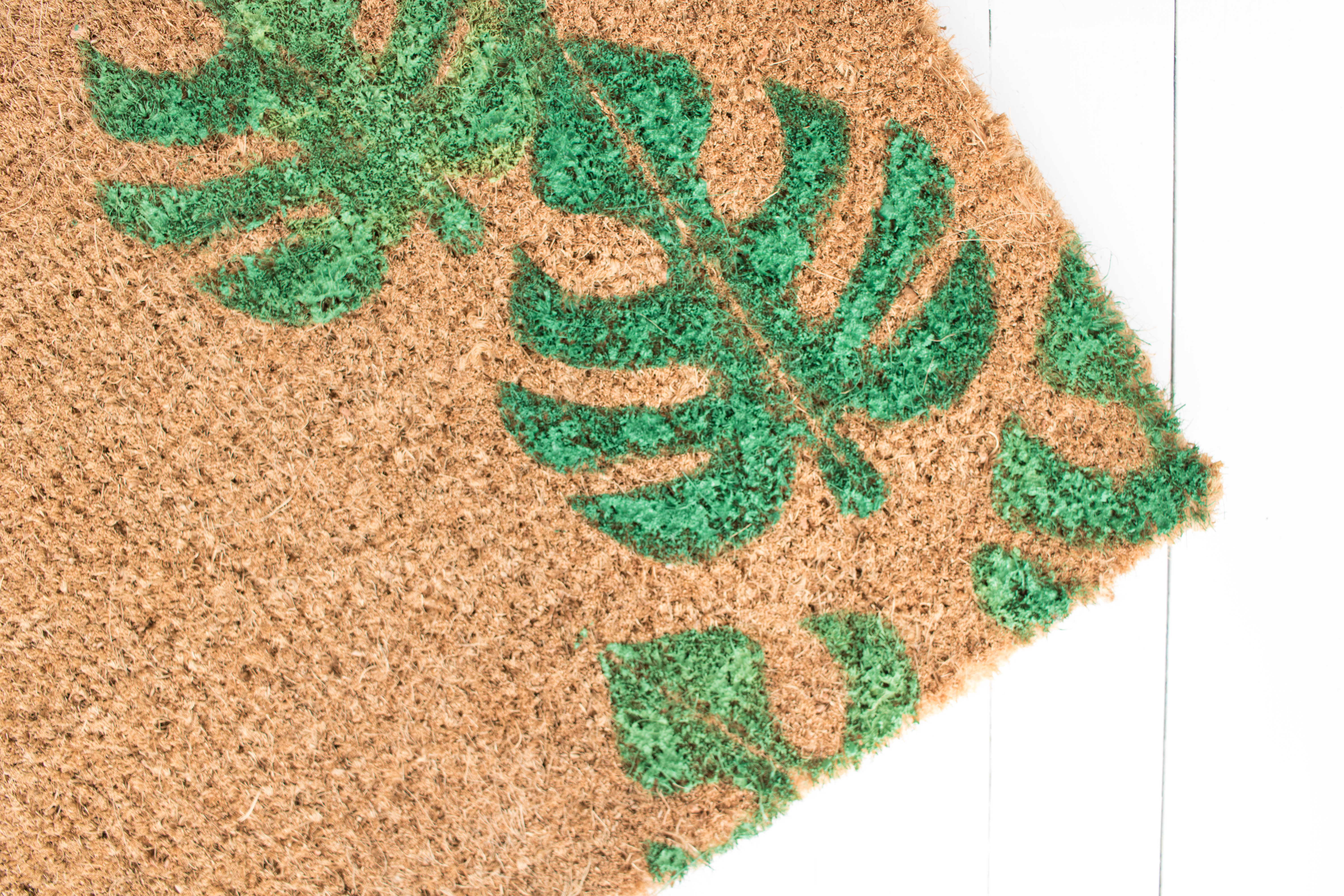 This easy DIY Monstera Doormat is a perfect way to bring a little bit of tropical to your entryway. Make one for a housewarming gift or keep it for yourself! #diy #doormat #monstera #modern #crafts #homedecor